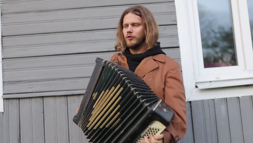 Male musician plays the accordion in the yard - Powered by Shutterstock - Get 15% off with code: PIKWIZARD15