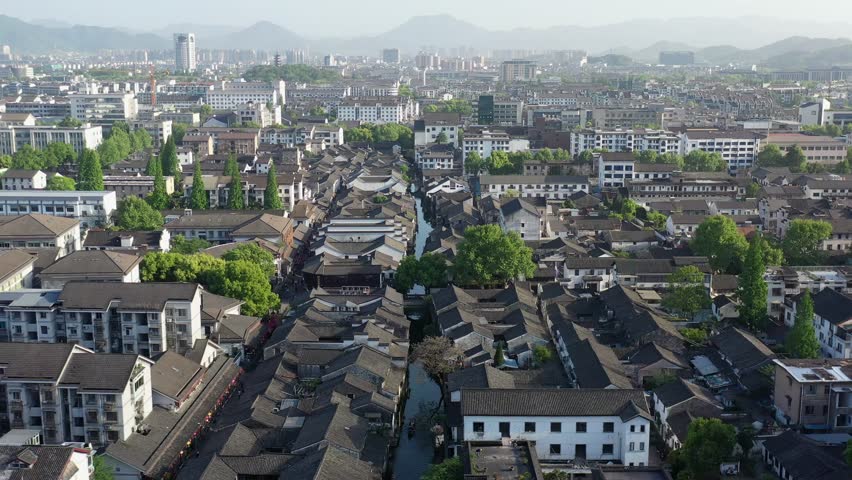 Discover the stunning architecture and rich history of Cangqiao Zhijie in Zhejiang Shaoxing. The vibrant cityscape showcases ancient buildings dotted among lush greenery.