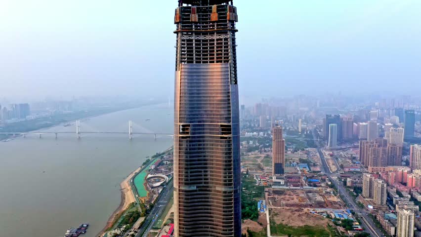 Explore the stunning skyline of Wuhan from an aerial perspective, featuring towering skyscrapers, the Yangtze River, and evolving city landscapes during dusk.