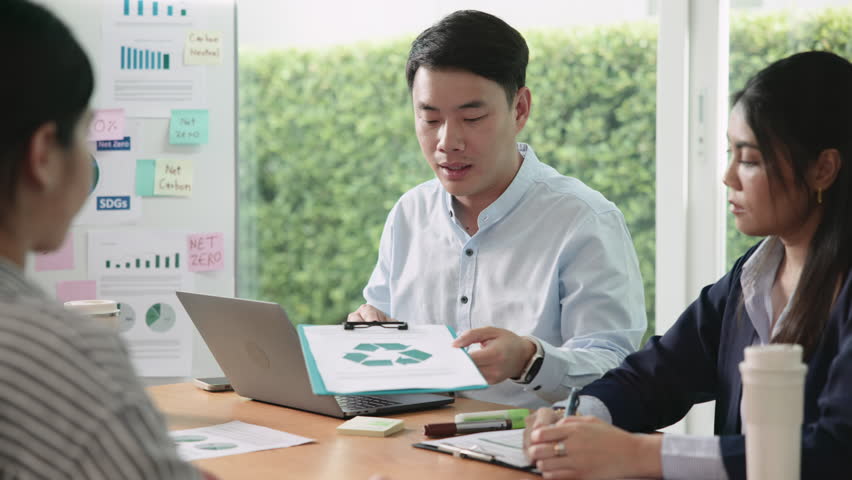 Young people asia man talk advice ESG work eco go green net zero waste SDGs growth hope clean energy control carbon credit offset recycle report. The way forward asian company workshop project office.
