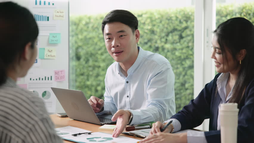 Young people asia man talk advice ESG work eco go green net zero waste SDGs growth hope clean energy control carbon credit offset recycle report. The way forward asian company workshop project office.