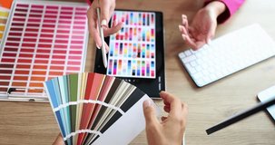 Designers discuss color palettes for project using digital tablet and color swatch. Professionals show collaborative process and color selection - Powered by Shutterstock - Get 15% off with code: PIKWIZARD15
