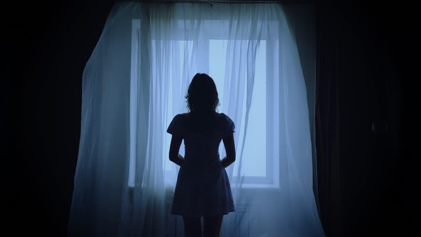 unrecognizable black dark silhouette of woman standing looking at window, mood depression sadness loneliness emotion. Mystery Adult Girl back rear view. wind blows curtains fly waving white fabric. 4k
