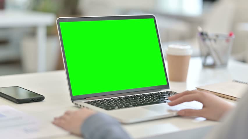 rear view of arab woman working on laptop with chroma key screen
