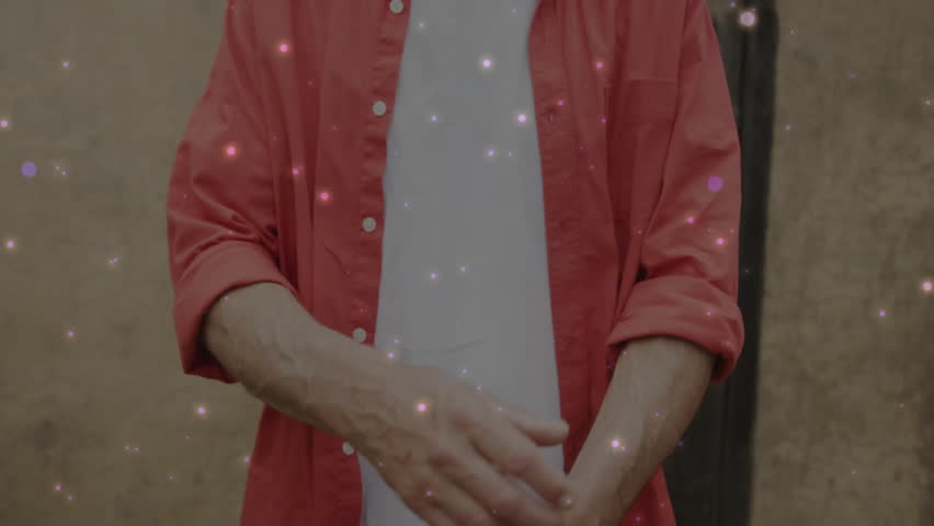 Man rolling up red shirt over white T-shirt in marketing clip, crossing arms showing confidence. Confident, casual, rustic, poised, outdoor, relaxed, masculinity