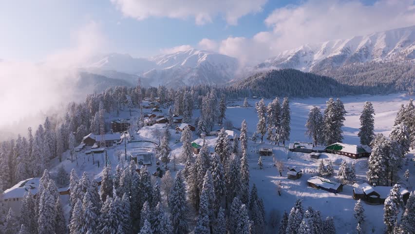 Drone shot of winter wonderland scene—hotels scattered across snowy hilltops.