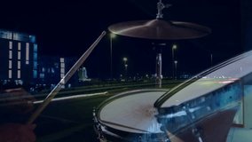 Drummer lifting sticks and alternating strikes on snare and hi-hat on rooftop for music production. Musician, nightlife, urban, rhythm, performance, minimalism, energetic - Powered by Shutterstock - Get 15% off with code: PIKWIZARD15