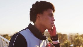 Man tapping earbud while tracking social media emoji reactions increasing around rooftop terrace. Technology, innovation, communication, urban, vibrant, digital, lifestyle - Powered by Shutterstock - Get 15% off with code: PIKWIZARD15