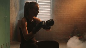 Women self defense girl power. Woman fighter preparing for fight puts on boxing gloves in locker room. Strong girl training punches ready for fight active exercise sparring workout training in gym - Powered by Shutterstock - Get 15% off with code: PIKWIZARD15