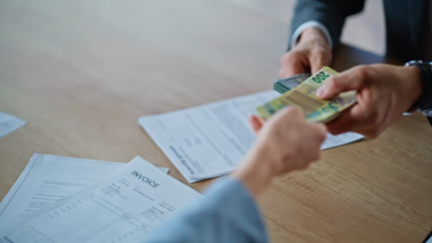 Businesspeople exchanging dollars euro in office buro closeup. Woman banker hands giving pack of cash to male client indoors. Entrepreneur receiving money from colleague at wooden table workplace