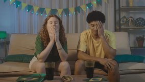 Multiracial couple reacts with frustration after a missed goal during a match at home. Wearing Brazil colors, they express disappointment and tension in a realistic fan moment.
 - Powered by Shutterstock - Get 15% off with code: PIKWIZARD15