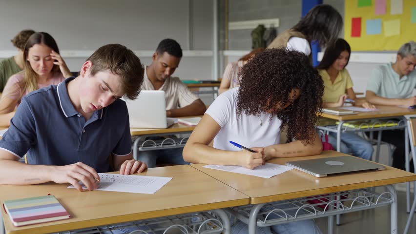 Group of college students doing exercise test exam at High School classroom