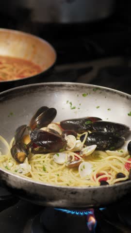 Chef Using Different Pans While Cooking Spaghetti Pasta With Seafood