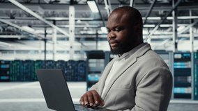 Close up of engineer in server room using laptop, executing security patches, verifying firewall configurations. Worker performing equipment vulnerability scans in data center, camera A - Powered by Shutterstock - Get 15% off with code: PIKWIZARD15