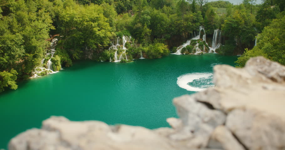 Emerald lake and cascading waterfalls among dense greenery at Plitvice Lakes National Park in Croatia