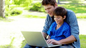 Father opening laptop and guiding son typing code as overlays appear on screen teaching technology. Educational, mentorship, outdoor, family, teamwork, innovation, learning - Powered by Shutterstock - Get 15% off with code: PIKWIZARD15