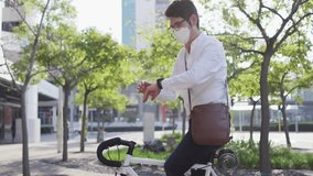 Man riding bicycle, checking smartwatch in plaza, summoning floating hearts and thumbs-up icons. Urban, technology, communication, modern, professional, lifestyle, fitness - Powered by Shutterstock - Get 15% off with code: PIKWIZARD15