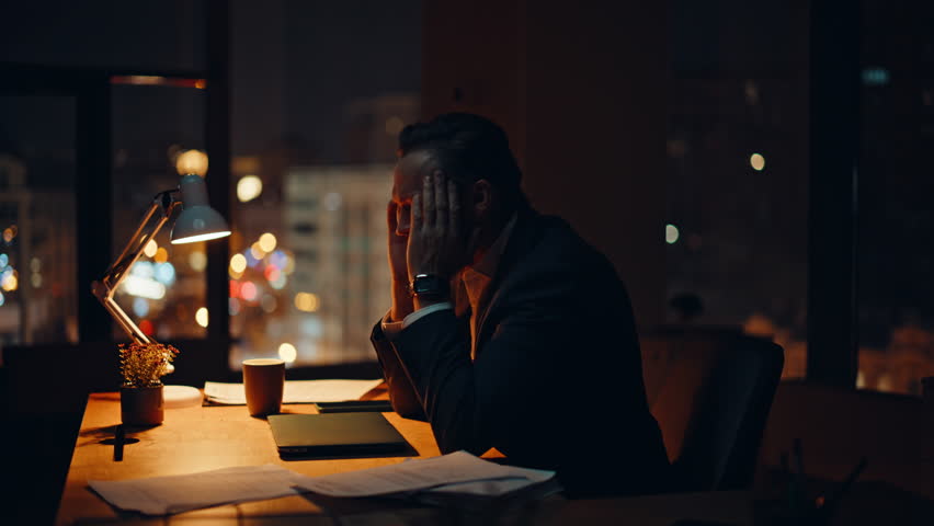 Overworked businessman sitting night office environment closeup. Fatigued man employee struggling motivation tired of exhausting schedule. Weary ceo massaging neck rubbing muscles at private cabinet