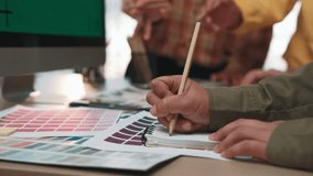 Team members collaborate in a modern office, surrounded by color swatches and design tools, showcasing creativity and teamwork in graphic design projects. SACTR - Powered by Shutterstock - Get 15% off with code: PIKWIZARD15