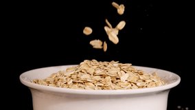 Oat grains cascade into a white bowl against a black background, highlighting texture and motion in a 26-second sequence - Powered by Shutterstock - Get 15% off with code: PIKWIZARD15