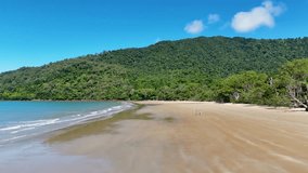 A couple strolls along a secluded beach in Port Douglas, under clear skies with lush greenery and gentle waves - Powered by Shutterstock - Get 15% off with code: PIKWIZARD15
