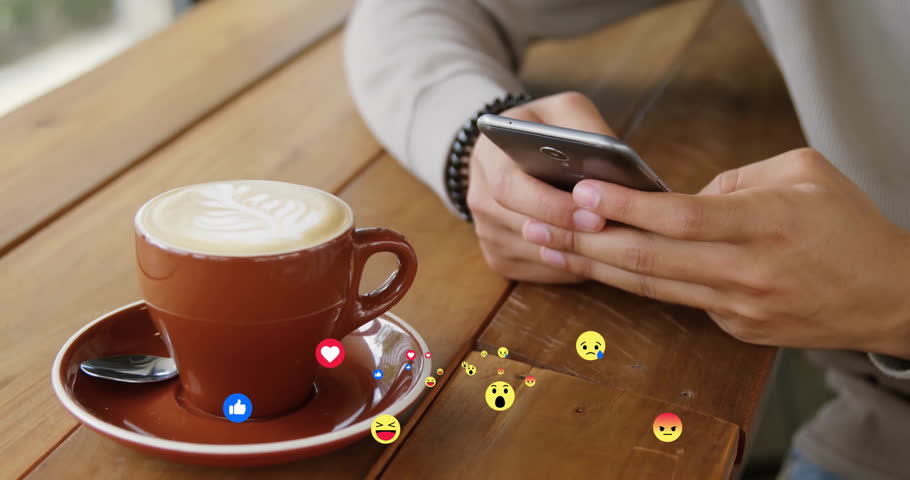 Picking up smartphone, man's hands scrolling emojis over café table showing technology feedback. Digital communication, social media, emoticons, casual lifestyle, modern technology, hospitality,