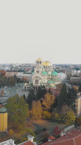 Aerial view of the magnificent Alexander Nevsky Cathedral in Sofia, Bulgaria, surrounded by autumn foliage. Vertical Video