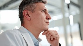 Professional scientist, dressed in a white lab coat and light blue shirt, thoughtfully pondering solutions in a bright laboratory environment. Focused and reflective. - Powered by Shutterstock - Get 15% off with code: PIKWIZARD15