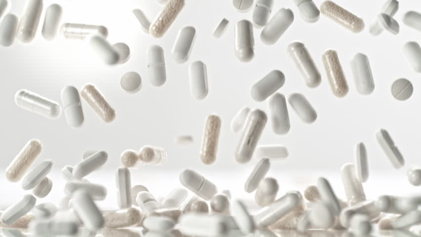 Super Slow Motion of Pills Falling on White Background at 1000fps.