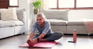 Senior woman stretching on yoga mat at home, enjoying peaceful exercise routine. Wellness, fitness, elderly, relaxation, home workout, meditation - Powered by Shutterstock - Get 15% off with code: PIKWIZARD15