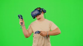 The man wearing VR headset playing in virtual reality game. The man gaming on chroma key green screen background in virtual reality. Concept enjoy game in VR headset leisure activity virtual reality - Powered by Shutterstock - Get 15% off with code: PIKWIZARD15