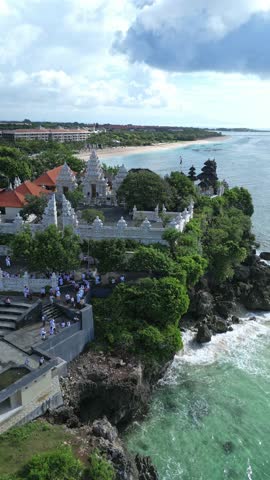 Aerial view of Hindu temple at Indian Ocean coastline of beautiful island of gods.Nusa Dua.Bali.Indonesia.Vertical video
