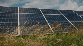 Overgrown solar power station with tall dry grass indicating lack of maintenance in renewable energy field installation. High quality 4k footage - Powered by Shutterstock - Get 15% off with code: PIKWIZARD15