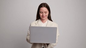 Young professional woman confidently working on laptop in minimalist office setting, embracing modern technology for efficiency and creativity - Powered by Shutterstock - Get 15% off with code: PIKWIZARD15
