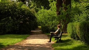 Man sits peacefully on a bench reading a book. Calm and thoughtful moment in urban or park setting. Great for lifestyle, mindfulness, or education visuals. - Powered by Shutterstock - Get 15% off with code: PIKWIZARD15