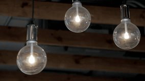 Three vintage style light bulbs hanging in darkness with flickering and swinging motion glowing filament against black background ideal for concept themes of energy ideas creativity and retro interior - Powered by Shutterstock - Get 15% off with code: PIKWIZARD15