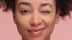 Playful woman winking with confident smile on pink background - Powered by Shutterstock - Get 15% off with code: PIKWIZARD15