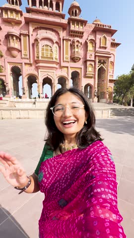 4K vertical selfie video of Indian woman wearing traditional saree and vlogging at Patrika Gate in Jaipur, Rajasthan, India. Travel blogger making content on location. Old Indian architecture.