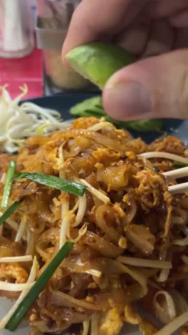 Classic Thai stir-fried noodle dish featuring rice noodles, shrimp, peanuts, bean sprouts, and lime.