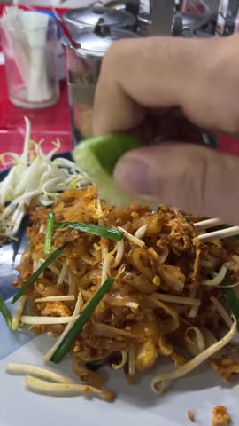 Classic Thai stir-fried noodle dish featuring rice noodles, shrimp, peanuts, bean sprouts, and lime.