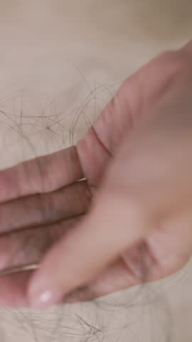 Close-up of woman holding hair in hand, showing emotional struggle with hair loss, aging, or hormonal changes. Great for medical or wellness content.