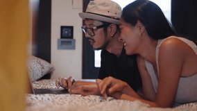 Young Asian couple using laptop in bed surfing the internet and watching a movie - Powered by Shutterstock - Get 15% off with code: PIKWIZARD15