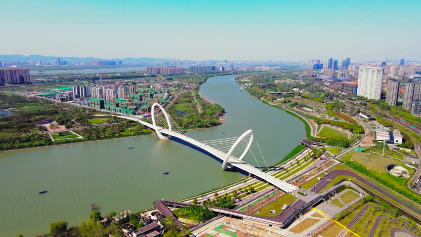 Witness breathtaking aerial views of the Nanjing Eye Yangzi River Walking Bridge. This architectural marvel spans the river, showcasing the city’s beauty and vibrant surroundings.