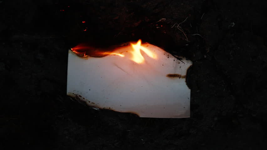 Burning and glowing photo or paper with fire flame and smoke on dark background