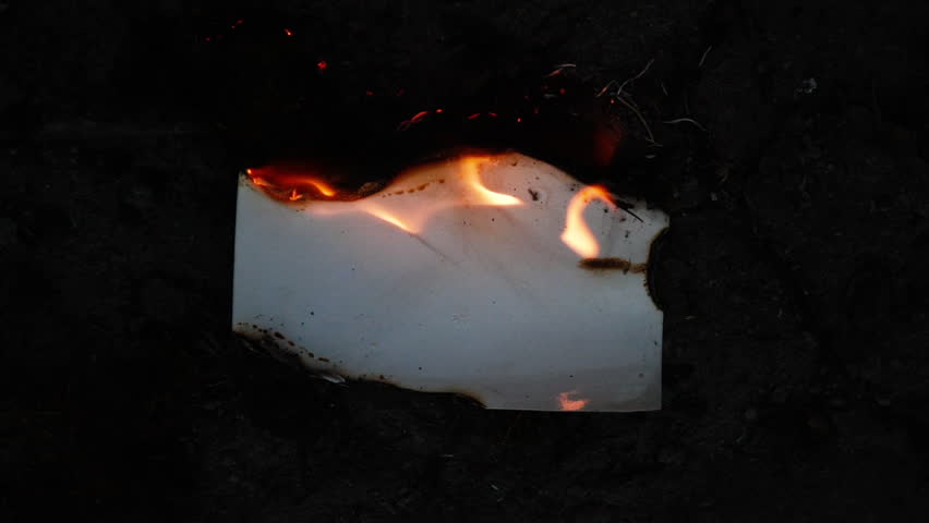 Burning and glowing photo or paper with fire flame and smoke on dark background