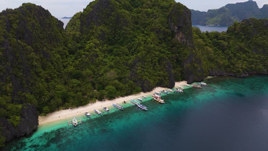 Wide Scenic Aerial Panorama of Bangka Boats Docked in Entalula Island’s Limestone Cliffs and Surrounding Islets in El Nido, Palawan, Philippines
