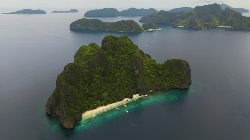 Wide Scenic Aerial Panorama of Bangka Boats Docked in Entalula Island’s Limestone Cliffs and Surrounding Islets in El Nido, Palawan, Philippines