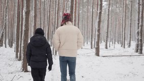 Two brothers walk away from the camera, taking a journey through a dense, snowy pine forest. The siblings explore the winter nature trail together, surrounded by tall trees and quiet wilderness. - Powered by Shutterstock - Get 15% off with code: PIKWIZARD15