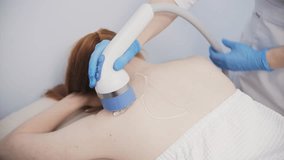 Shockwave therapy on woman upper back in clinic - Powered by Shutterstock - Get 15% off with code: PIKWIZARD15