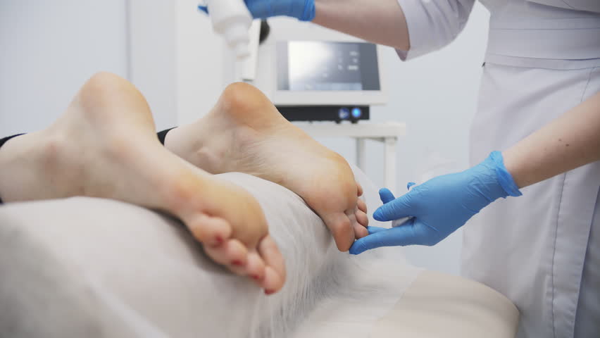 Preparing foot for shockwave therapy in medical clinic